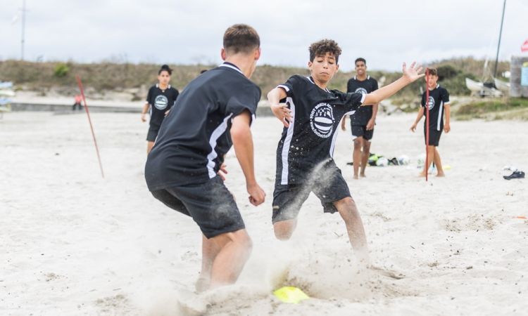 jeunes jouant au foot sur la plage.jpeg